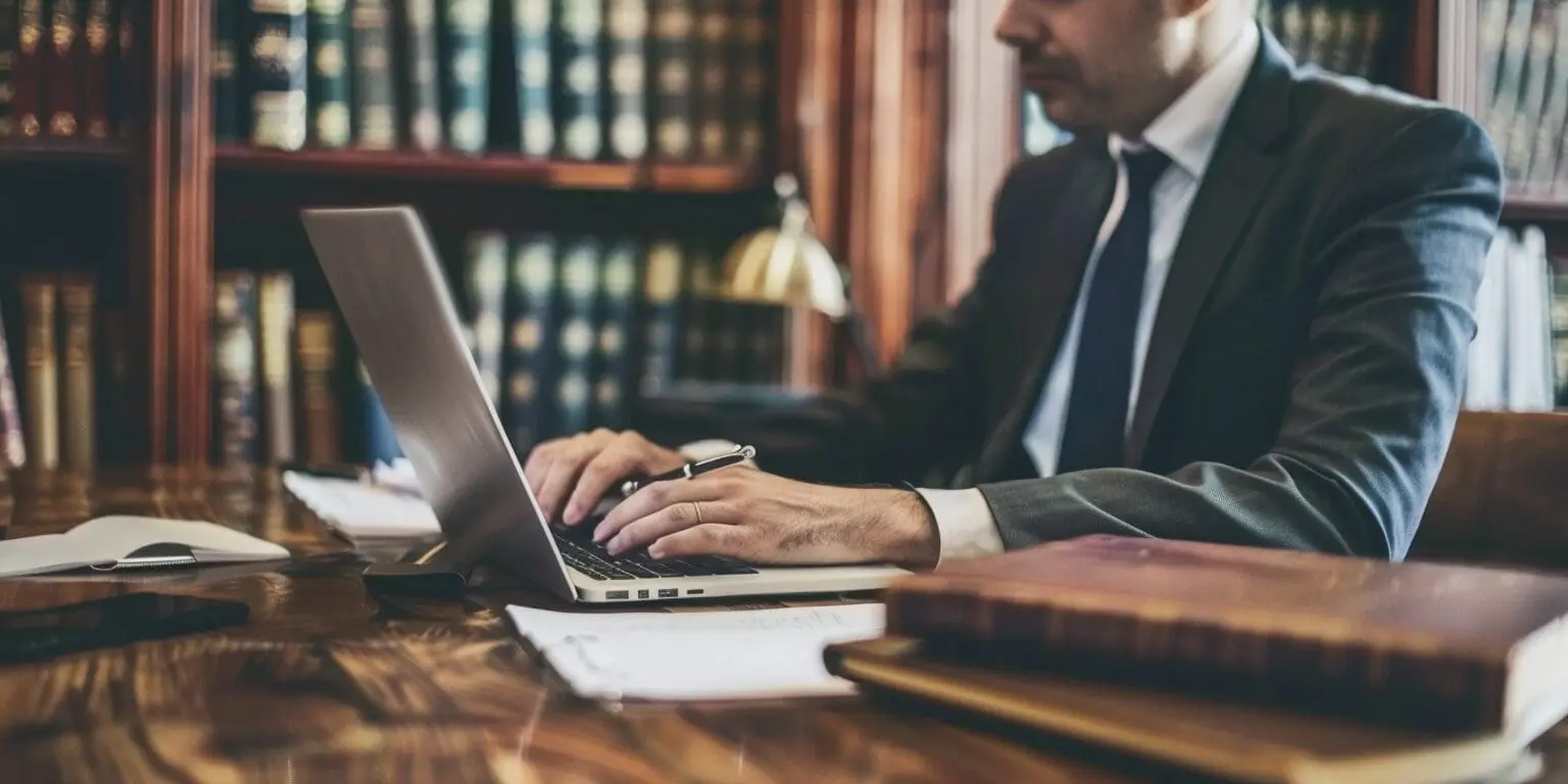 a lawyer at a desk using a laptop